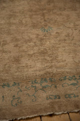 Antique Peking rug close-up: even short beige pile, seafoam green curvilinear motif, fringed edge.