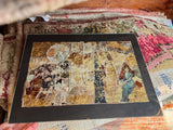Angled view of Lillian Shad's framed mixed media art with textured collage and gold leaf.