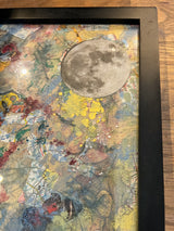 Angled view of the textured moon element over a colorful map collage.