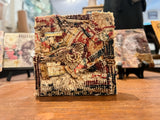 Side view of the mixed media art block showing its layered, textured surface.