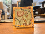 Persian Flower mixed media art featuring textural antique rug fragments and fibers.
