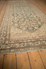 Low angle view down the distressed Persian runner, detailing the meandering vine border.
