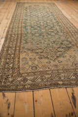 Angled perspective of a distressed Hamadan runner highlighting its heavy color abrashes and low pile.