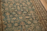 Angled view of the distressed pile, showing Mahi Mahi motifs and the meandering vine border.