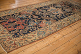 Angled view of an antique Malayer runner showing its fine detail and contrasting navy, red, and beige palette.