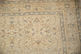 Distressed vintage Kaisary rug corner: faded blue border, ivory floral field, and visible wear.
