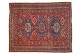 Antique Caucasian Soumac carpet with three geometric medallions in blue and blush on a red field of blossoms.