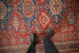 Intricate botehs and roundel medallions on the cherry red field of an antique Caucasian Soumac carpet.