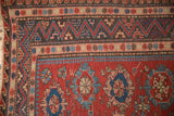 Mountainous meandering vine and wave motif borders on an antique Caucasian Soumac carpet.