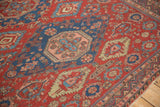 Angled detail of an antique Soumac's geometric medallions and reciprocating wave border.