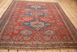 Angled view of an antique Caucasian Soumac showing the triple geometric medallions on a rich red ground.