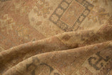 Soft, time-softened pile of a distressed Turkish Oushak in muted mauve and gold.