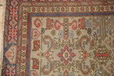 Corner detail of a vintage Shirvan rug with a geometric Kufic border and low-pile texture.