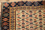 Corner detail of an antique Kurdish rug showing geometric cloudband and floral borders.