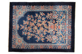 A vintage Art Deco carpet with a potted Tree of Life and dragon design on a cobalt blue field.