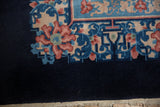 Corner detail of a vintage Art Deco carpet showing the cobalt field and stylized floral border.