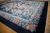 Angled view of a vintage Art Deco rug showing its dragon motif and intricate floral border.