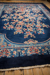 Low angle view of a vintage Art Deco carpet showing the floral pile and scattered white knot heads.