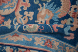 Dragon and floral details on the short, dense pile of a folded Art Deco carpet.