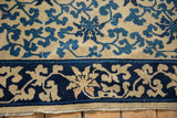 Worn selvage and navy blue scrolling vine border of an antique Chinese Peking carpet.