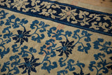 Close-up of threadbare wear revealing the knot heads of a scrolling vine Peking carpet.