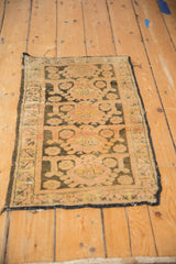 Angled view of a distressed Kars rug mat with a geometric design and time-softened colors.