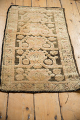 The repeating cloudband motif and distressed pile of a vintage Kars rug fragment, viewed at length.
