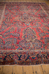 Angled perspective showing the lustrous short pile and allover floral sprays on an antique Sarouk carpet.