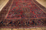 Low angle view showing the lustrous pile and intricate floral field of an antique Sarouk carpet.
