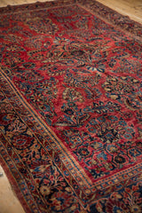 Rich, lustrous pile of an antique Sarouk carpet highlighting raspberry red and navy floral sprays.