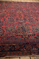 Low angle view of the antique Sarouk's raspberry red field and dense navy floral sprays.