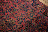 Angled perspective on the antique Sarouk carpet's floral sprays and aged surface patina.