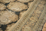 Detailed view of the distressed pile showing Rococo-style bouquets and the carpet's border.