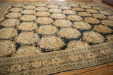 Angled view across the staggered Rococo panels of a distressed antique Tabriz carpet.
