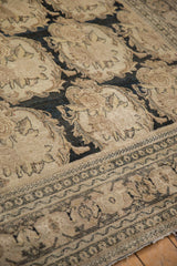 Worn, low pile of an antique Tabriz with charcoal Rococo motifs on an ivory background.