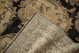 Flipped corner of a distressed antique Tabriz carpet revealing its hand-knotted foundation.