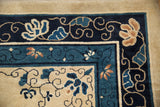 Floral and vine motifs in the navy and cobalt blue corner borders of an antique Peking carpet.