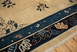 Detail of an antique Peking carpet's border with scrolling vines and blossoms in navy blue.