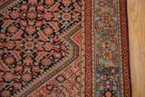 A Malayer rug's corner showing the rose spandrel, navy Herati field, and sky blue floral border.