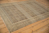 Distressed vintage Malayer rug showcasing intricate Herati pattern with time-softened beige and silver tones.
