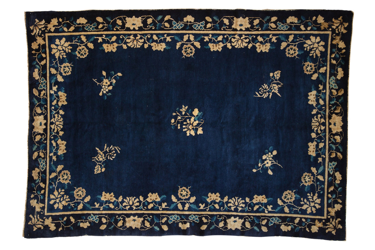 Antique Peking carpet with scattered floral sprays on a cobalt blue field and a floral bine border.
