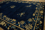Angled view of the Chinese Peking carpet's floral border against its deep cobalt blue field.