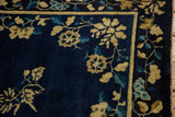 Close-up of the densely ornamented floral bine and blossom border on a cobalt blue carpet.