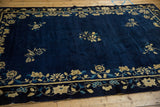 Angled view of the antique Peking carpet's rich cobalt blue wool and scattered floral sprays.