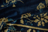 Close-up of the antique Peking carpet's plush, deep cobalt blue pile and sand floral accents.