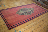 Angled perspective of the antique Doroksh rug runner, showing its raspberry red field and central medallion.