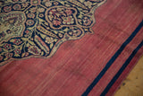 Time-softened cochineal red field with rewoven navy stripes on an antique Doroksh rug corner.