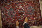 Overhead view of a vintage Karaja rug's bold triple medallion design and intricate serpent border.