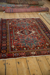 Vintage Karaja rug's geometric triple medallion and serpent border viewed from an angle.