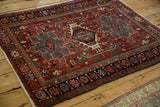 Angled view of a vintage Karaja rug detailing its geometric triple medallion and complex borders.